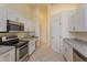 Kitchen with granite countertops, stainless steel appliances, white cabinets, and tile floor at 300 Churchill Dr, Longwood, FL 32779