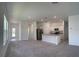 Bright, open-concept living area with plush carpeting and a modern kitchen island at 3087 Sunset Hills Rd, Winter Haven, FL 33881
