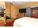 Bedroom features a television over a dresser, a large chest of drawers, and white bed at 330 Phoenix Ave, Daytona Beach, FL 32118