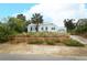 A quaint home with light blue shutters and a well-maintained lawn, complemented by mature palm trees at 330 Phoenix Ave, Daytona Beach, FL 32118