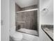 Bathroom featuring a tiled shower, glass door, and granite countertop at 3321 Crimson Ln, Deltona, FL 32738