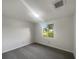 Bright bedroom with neutral walls, plush carpeting, and a window overlooking the yard at 3321 Crimson Ln, Deltona, FL 32738