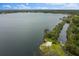 Scenic aerial view of the lakefront with mature trees and lush landscaping on a bright, sunny day at 334 N Shadowbay Blvd, Longwood, FL 32779