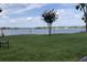 Scenic lake view with lush green grass, framed by a flowering tree and tranquil blue water at 334 N Shadowbay Blvd, Longwood, FL 32779