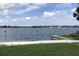 Beautiful lake view featuring a sandy beach, picnic tables, and calm waters under a partly cloudy sky at 334 N Shadowbay Blvd, Longwood, FL 32779
