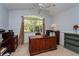Bright office space featuring a large window, ceiling fan, and spacious wooden desk for a comfortable work environment at 334 N Shadowbay Blvd, Longwood, FL 32779