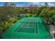 Aerial view of a well-maintained tennis court surrounded by lush greenery, perfect for sports enthusiasts at 334 N Shadowbay Blvd, Longwood, FL 32779