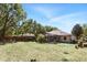 Spacious backyard featuring a screened-in patio, mature trees, and a well-manicured lawn at 3451 Players Point Loop, Apopka, FL 32712