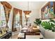 Elegant dining room featuring decorative curtains, a chandelier, and a large art piece at 3451 Players Point Loop, Apopka, FL 32712