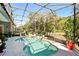 Relaxing screened-in pool area with a unique shape, lush greenery, and ample space for outdoor lounging at 3451 Players Point Loop, Apopka, FL 32712