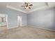 Large bedroom with tray ceiling, ceiling fan, and doorways leading to the bathroom and closet at 3925 Green Sabal Dr, Orlando, FL 32824