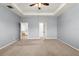 Spacious bedroom featuring a tray ceiling, ceiling fan, and multiple doorways to connecting spaces at 3925 Green Sabal Dr, Orlando, FL 32824