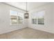 Dining area with tile flooring, modern chandelier and natural light from dual windows at 3925 Green Sabal Dr, Orlando, FL 32824