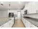 Modern kitchen showcasing white cabinetry, granite countertops, stainless steel appliances, and a spacious island at 3925 Green Sabal Dr, Orlando, FL 32824