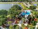 Aerial view of community pool, playground, and clubhouse amenities next to a small lake and mature trees at 4249 Andover Cay Blvd, Orlando, FL 32825