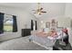 Spacious bedroom featuring a ceiling fan, plush carpeting, and abundant natural light from large windows at 4249 Andover Cay Blvd, Orlando, FL 32825