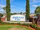 Community sign for Andover Cay framed by manicured landscaping, trees, and a glimpse of a nearby lake at 4249 Andover Cay Blvd, Orlando, FL 32825