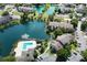 Scenic aerial view of condo community with lake, pool, and mature trees on a sunny day at 4704 Walden Cir # 21, Orlando, FL 32811