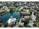 Expansive aerial view of condo community, featuring a pool, lake with fountain, and lush landscaping at 4704 Walden Cir # 21, Orlando, FL 32811