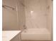 Bright bathroom with white marbled tile and a tub with a shower and modern fixtures at 4704 Walden Cir # 21, Orlando, FL 32811