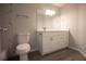Bathroom with tile shower, white vanity, large mirror, modern lighting, white toilet and light-wood look flooring at 4704 Walden Cir # 21, Orlando, FL 32811