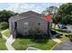 Two-story condo with tan siding, black stairs, landscaping, and mature tree at 4704 Walden Cir # 21, Orlando, FL 32811
