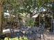 Beautiful backyard patio with mature trees, outdoor seating area, and lush landscaping at 5127 Leeward Way, Orlando, FL 32809