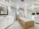 Luxurious bathroom featuring double vanities, a soaking tub, and neutral tile at 5127 Leeward Way, Orlando, FL 32809
