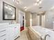 Bright bathroom featuring a soaking tub, large vanity, and a framed mirror at 5127 Leeward Way, Orlando, FL 32809