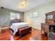 Charming bedroom featuring a comfortable bed, hardwood floors, and plenty of natural light at 5127 Leeward Way, Orlando, FL 32809