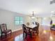 Elegant dining room with hardwood floors, decorative lighting, and ample natural light from the window at 5127 Leeward Way, Orlando, FL 32809