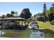 Picture of lakefront dock with boat lifts, covered seating area, and an American flag at 5127 Leeward Way, Orlando, FL 32809