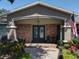 Inviting front porch with brick accents, decorative sconces, and a stylish double door entry at 5127 Leeward Way, Orlando, FL 32809