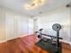 Gym featuring hardwood floors, weights, lighting, and white bi-fold closet doors at 5127 Leeward Way, Orlando, FL 32809