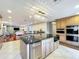 Open-concept kitchen boasts an island with granite counters, and stainless steel appliances, connecting to the living room at 5127 Leeward Way, Orlando, FL 32809