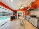 An outdoor kitchen boasts stainless steel appliances, an island, and access to the pool area for convenient entertaining at 5127 Leeward Way, Orlando, FL 32809