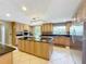 Luxury kitchen with large island, custom cabinets, granite counters, and stainless steel appliances at 5127 Leeward Way, Orlando, FL 32809