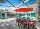 Outdoor dining near a screened-in pool, offering ample seating and a relaxed atmosphere for entertaining and leisure at 5127 Leeward Way, Orlando, FL 32809