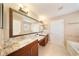 Beautiful bathroom featuring double sinks, granite countertops, and a large decorative mirror at 5262 Baskin St, Orlando, FL 32814