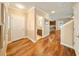 Hallway with hardwood floors leads to powder room, kitchen and living spaces at 5262 Baskin St, Orlando, FL 32814