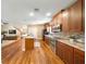 Open kitchen boasts granite counters, stainless appliances and wood cabinets and flooring at 5262 Baskin St, Orlando, FL 32814