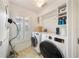 Well-lit laundry room with washer, dryer, storage shelves, and natural light from a window at 5262 Baskin St, Orlando, FL 32814