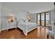 Bright primary bedroom with white furnishings, hardwood floors, and access to a private balcony at 5275 S Atlantic Ave # 506, New Smyrna Beach, FL 32169