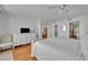 Bright main bedroom featuring hardwood floors, ceiling fan, and ensuite bathroom at 5275 S Atlantic Ave # 506, New Smyrna Beach, FL 32169