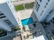 Top down view of pool area nestled between beachfront condo towers with spa and lounge chairs at 5275 S Atlantic Ave # 506, New Smyrna Beach, FL 32169