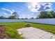 Private backyard boasts a stone fire pit, a large paved area, a white privacy fence, and lush green grass at 554 Appleton Pl, Oviedo, FL 32765