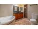 Luxurious bathroom features a soaking tub, glass shower, dual sinks and granite counters at 554 Appleton Pl, Oviedo, FL 32765