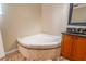 Corner bathtub and granite vanity with a framed mirror at 554 Appleton Pl, Oviedo, FL 32765