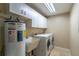 Well-equipped laundry room includes a utility sink, washer, dryer, and water heater at 554 Appleton Pl, Oviedo, FL 32765