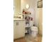 Bathroom featuring a modern toilet, storage shelving, double sinks with granite, and neutral color scheme at 5897 Soter Ln, Windermere, FL 34786